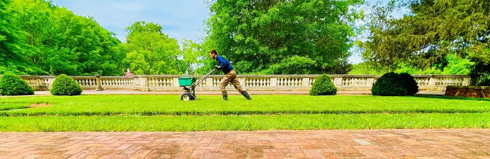 Tech spreading fertilizer on lawn